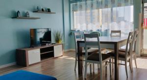 een eetkamer met een tafel en stoelen en een tv bij Apartamento T3 Aquazul in Portimão