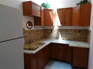 a kitchen with wooden cabinets and a white refrigerator at Kapka Apartments in Kiten