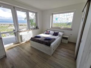 a bedroom with a bed in a room with windows at Surf camp in Krynica Morska
