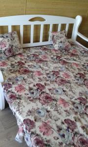 a bed with a floral comforter and two pillows at Apartment Moe More in Odesa