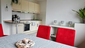 a kitchen with a table and two red chairs at Ferienwohnung Weinheim Stadler in Weinheim
