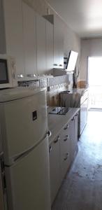 Apartment Moe More في أوديسا: مطبخ فيه دواليب بيضاء وثلاجة بيضاء