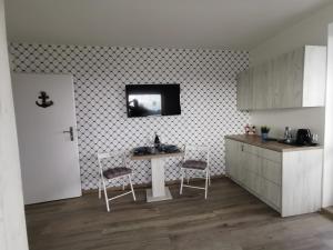 a kitchen with a table and two chairs in it at Surf camp in Krynica Morska