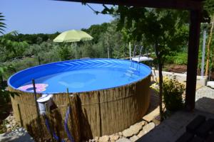 a hot tub in a garden with an umbrella at Apartment Lucy in Bajčići