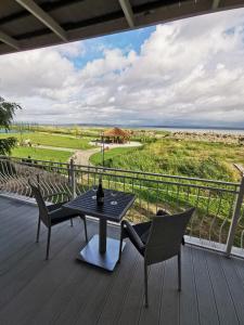a table and chairs on a deck with a view of the ocean at Surf camp in Krynica Morska