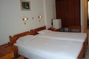 Karis Hotel في بلدة كوس: غرفة نوم بسرير كبير مع شراشف بيضاء