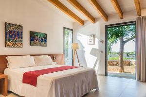ein Schlafzimmer mit einem Bett und einem großen Fenster in der Unterkunft Hotel Rural Sant Joan de Binissaida in Es Castell