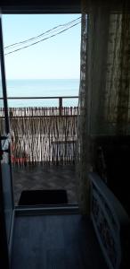 uma porta para uma varanda com vista para o oceano em Apartment Moe More em Odessa