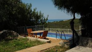 um pátio com uma mesa e cadeiras ao lado de uma piscina em Villa Kirişhome em Patara