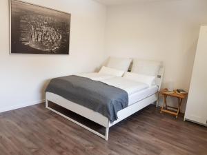 Un dormitorio con una cama blanca con una foto en la pared en Ferienappartement Jung, en Kamp-Lintfort