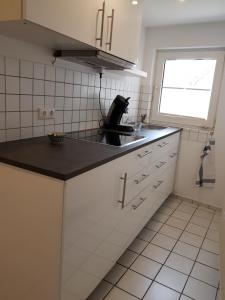 uma cozinha com um balcão preto e um lavatório em Ferienappartement Jung em Kamp-Lintfort