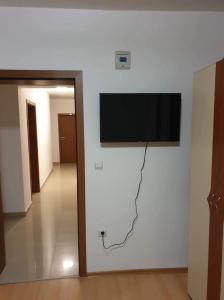 TV de pantalla plana colgada en la pared en Marianas Guesthouse en Obzor