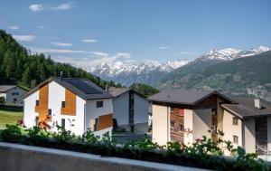 eine Reihe von Häusern mit Bergen im Hintergrund in der Unterkunft Arve-Visperterminen in Visperterminen