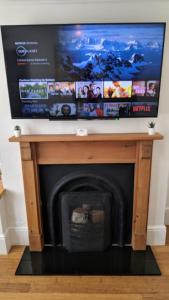 a tv over a fireplace with a tv above it at Victoria House in Exeter