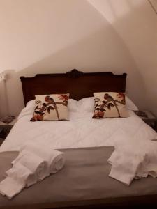 - un lit avec des draps et des oreillers blancs dans l'établissement La Rosa dei Sassi, à Matera