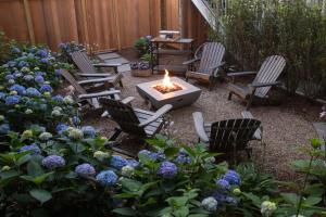 un patio trasero con sillas, una hoguera y flores en Carlisle House Inn, en Nantucket