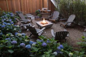 einen Hinterhof mit Stühlen, einer Feuerstelle und Blumen in der Unterkunft Carlisle House Inn in Nantucket