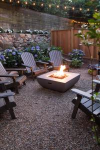 a fire pit in a patio with two chairs and benches at Carlisle House Inn in Nantucket