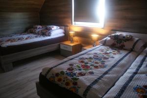um quarto com 2 camas individuais e uma janela em Agrodomki Okej-Biały Dom em Gardna Wielka