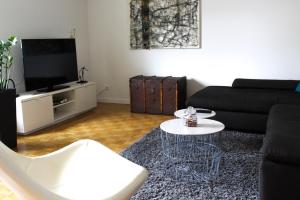 a living room with a black couch and a table at Großzügige helle Ferienwohnung bis 4 Personen in Chalampe, Elsass in Chalampé