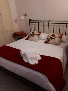 - une chambre avec un lit doté de draps et d'oreillers blancs dans l'établissement La Rosa dei Sassi, à Matera