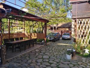 un patio con tavolo, sedie e una casa di Pensiunea Sandra a Sibiel
