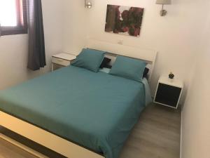 sypialnia z dużym łóżkiem i niebieskimi poduszkami w obiekcie Los Panelos B1 w Puerto del Carmen