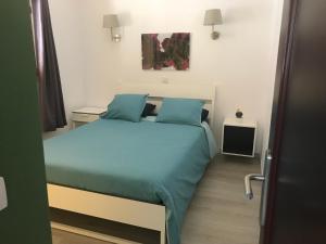 sypialnia z łóżkiem z niebieskimi poduszkami w obiekcie Los Panelos B1 w Puerto del Carmen