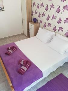 科托尔Bestie House的一间卧室配有一张床,并备有2个拖鞋