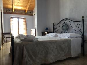 a bedroom with a large bed with white sheets at Sa Crannaccia in Càbras