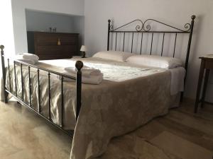 1 dormitorio con 1 cama grande con marco de metal en Sa Crannaccia, en Cabras