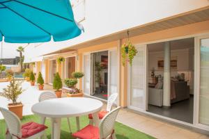 eine Terrasse mit einem weißen Tisch und Stühlen sowie einem Sofa in der Unterkunft Casa Golfinho in Viana do Castelo