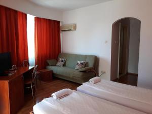 a hotel room with two beds and a couch at Pensiunea Sydney in Timişoara