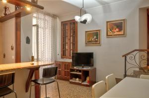 a living room with a television and a table and chairs at Casa Tinin in Loano