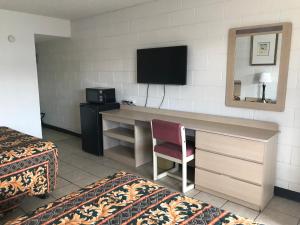 a hotel room with a desk and a television at Super Lodge Motel El Paso in El Paso