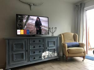 TV en la parte superior de un tocador en la sala de estar en Ella2, en Grömitz