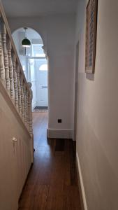 pasillo con escalera blanca y puerta blanca en Victoria House, en Exeter