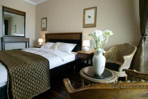 1 dormitorio con 1 cama y un jarrón de flores sobre una mesa en Arena Regia Hotel & Spa - Marina Regia Residence, en Mamaia Nord – Năvodari