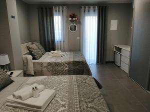 um quarto de hotel com duas camas com toalhas e um espelho em Anevan em Vidago