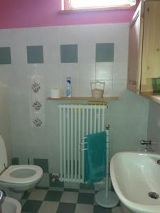 ein Badezimmer mit einem WC, einem Heizkörper und einem Waschbecken in der Unterkunft Residenza il bosco in Prada