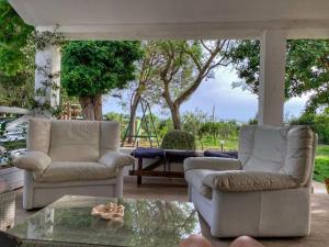 two chairs and a coffee table on a porch at AGRIB&B Il Pomo d'oro in Assemini