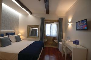 ein Schlafzimmer mit einem Bett, einem Schreibtisch und einem Tisch in der Unterkunft Quinta Vale do Homem in Amares + 37 Fotos