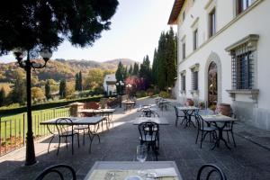 a patio with tables and chairs in front of a building at Villa Campestri Olive Oil Resort in Vicchio