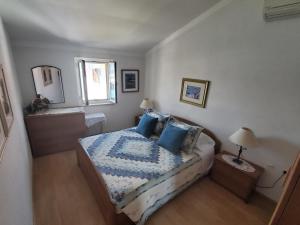 a bedroom with a bed with blue pillows and a window at Valun Seaside Apartments in Valun