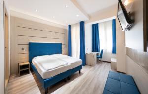 a bedroom with a blue bed and a tv at Hotel Gardenia in Caorle +55 photos