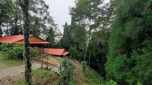 a building with a red roof next to some trees at Orion Retreat in Darjeeling
