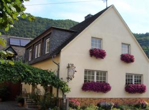 ein weißes Haus mit lila Blumen an den Fenstern in der Unterkunft Gästehaus Weberskirch in Ernst