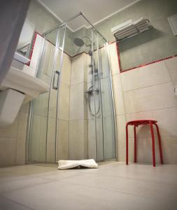 La salle de bains est pourvue d'une douche et d'un tabouret rouge. dans l'établissement Pensiunea Margareta, à Alba Iulia