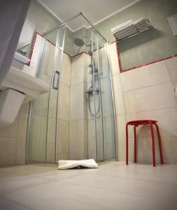 bagno con doccia e sgabello rosso di Pensiunea Margareta a Alba Iulia