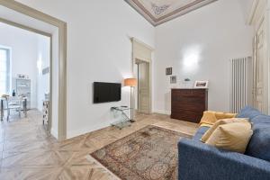 salon z niebieską kanapą i telewizorem w obiekcie Apartments to Art w Turynie